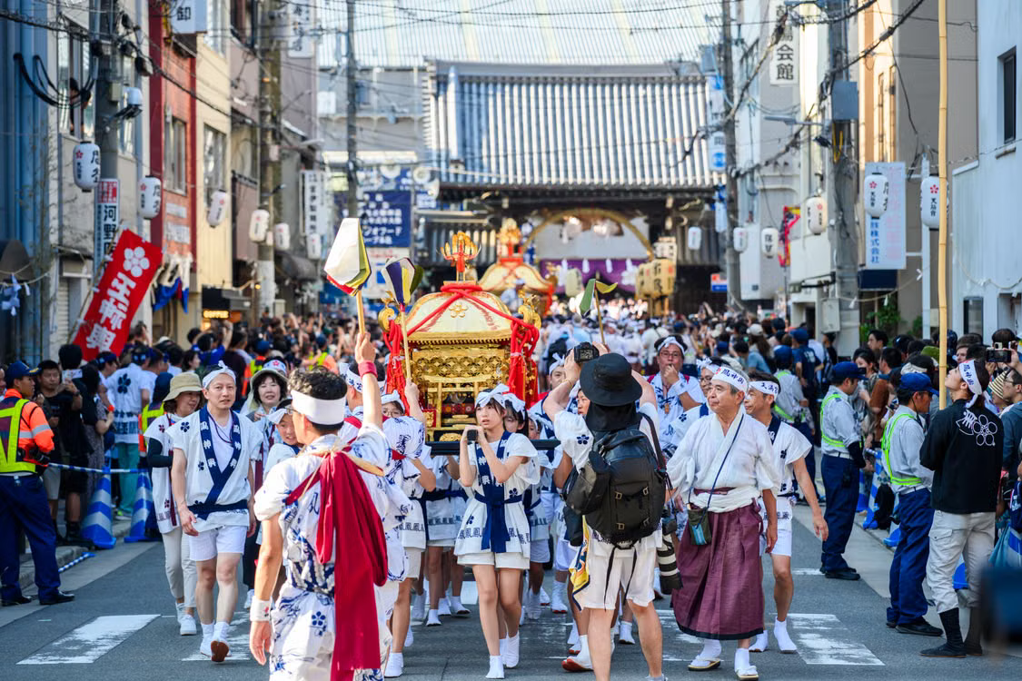 Street festival procession moving through a crowded Japanese neighborhood