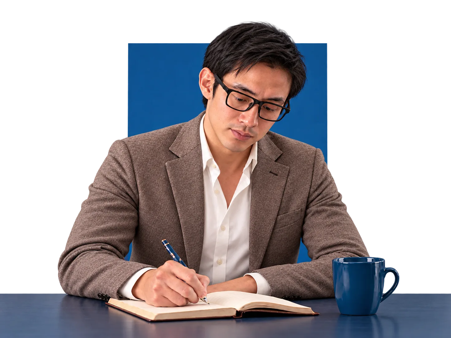 The author writing in a notebook at his desk